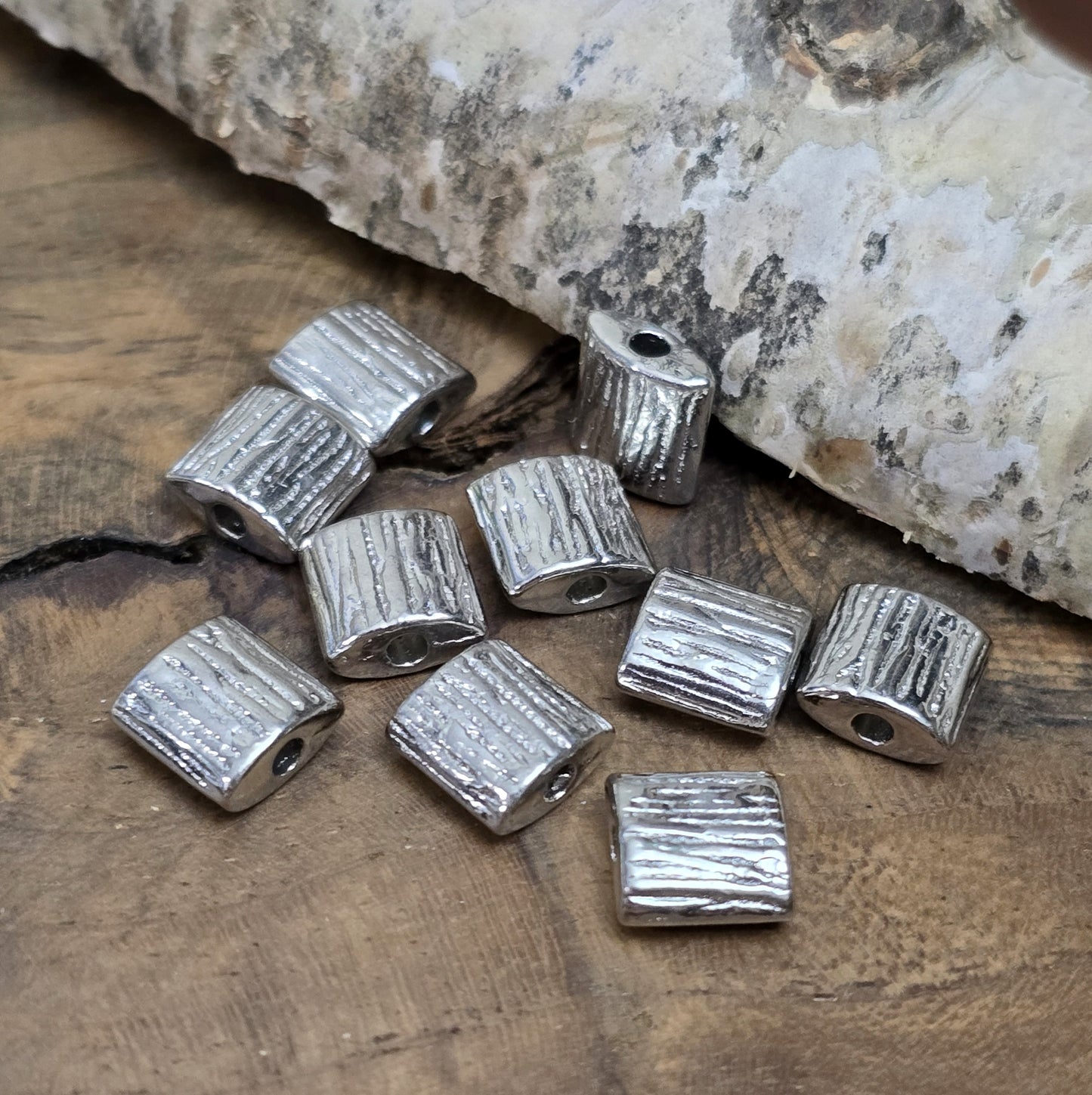10 antiksilberfarbene Metallperlen in Kissenform, 8 x 8 mm, mit strukturierter Oberfläche. Ideal für Schmuckdesigns wie Ketten, Armbänder oder kreative Dekorationen. Sie setzen stilvolle Akzente in jedem Projekt.