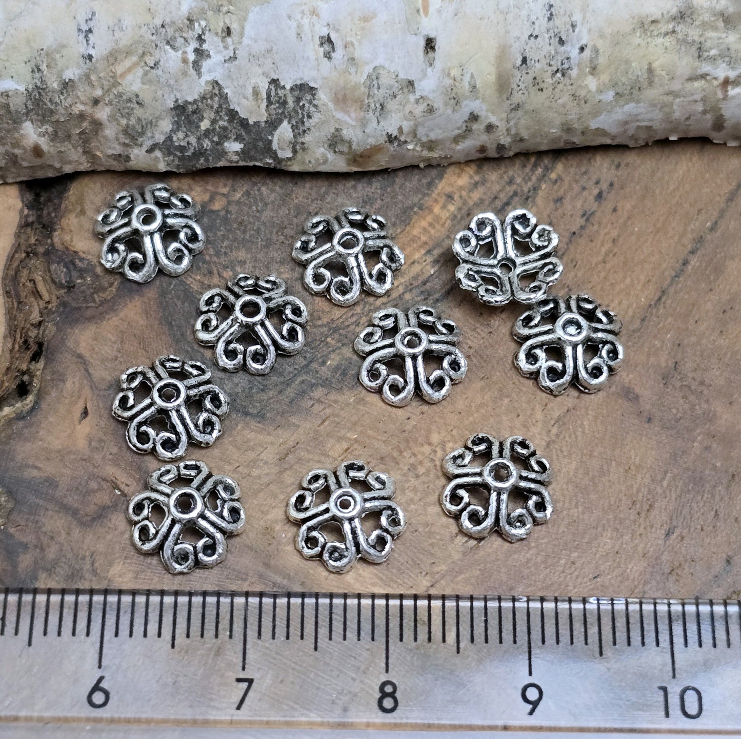 20 filigrane Perlenkappen in antik silberfarbener Optik, gestaltet in Form von Blumen oder Kleeblättern. Perfekt zum Verzieren und Schützen von Perlen und zur Veredelung von Schmuckstücken.