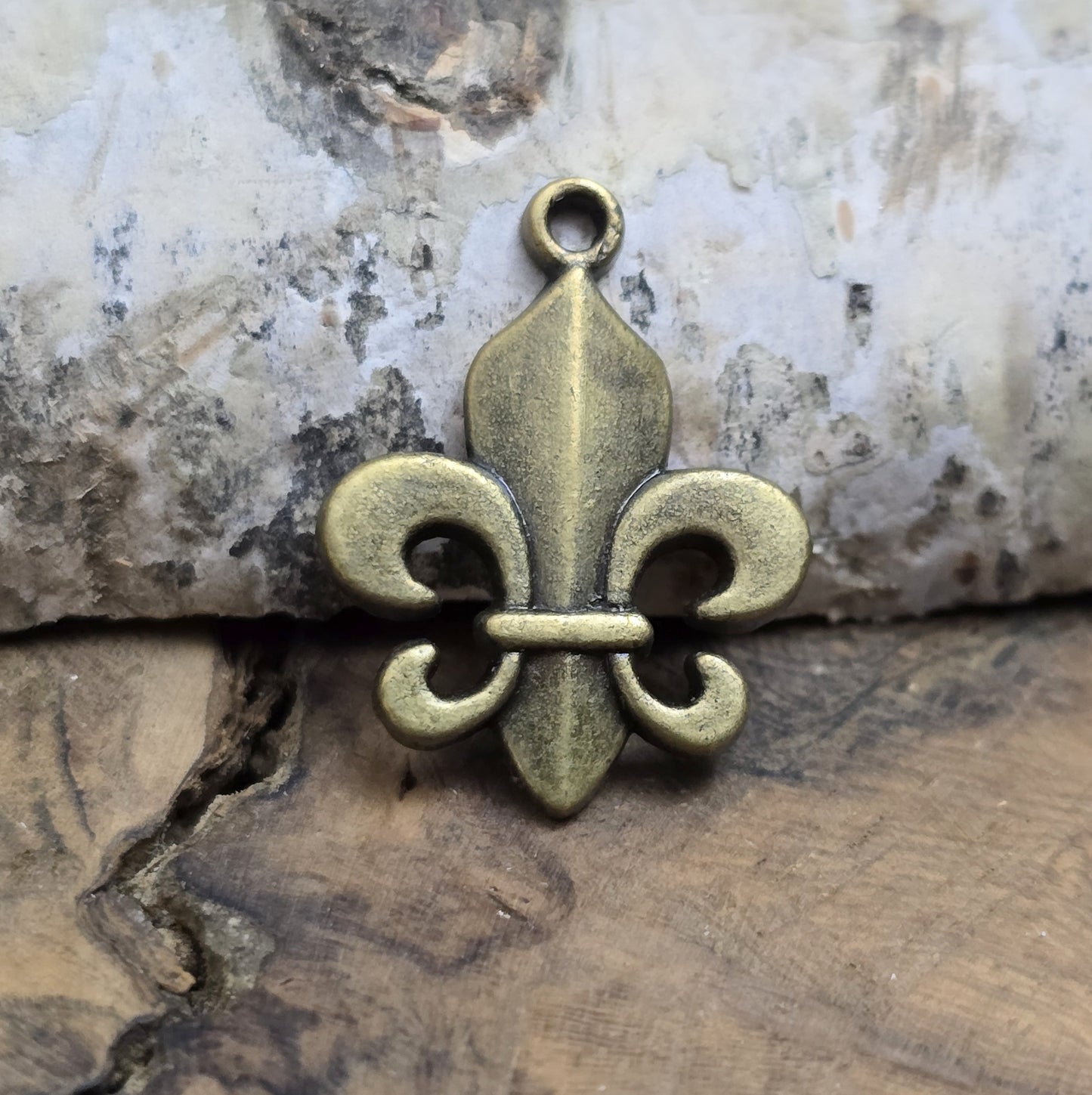 Das Bild zeigt 3 Anhänger Fleur de Lys 22mm, antik bronzefarbig. Ideal für die individuelle Schmuckfertigung.