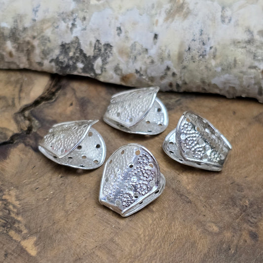 8 Bandenden/Bandklemmen - Endkappen - silberfarbig
Diese Bandenden sind perfekt für breite, weiche Stoffbänder wie Organza, Satin oder Chiffon. Um sie zu befestigen, kannst du das Bandende raffen, mit einem Perlenfaden umwickeln und diesen durch das Loch in der Kappe fädeln. Mit einer Perle und einem Crimp gesichert, wird die Kappe anschließend zusammengedrückt – fertig ist die stabile Schlaufe für Verschlüsse oder Dekorationen.