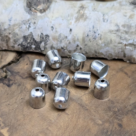 Das Bild zeigt Endkappen mit Loch rhodiumfarben - 6 x 7 mm
Diese Schmuckkappen in schlichter Form sind die perfekte Ergänzung für deine kreativen Projekte. Mit einer Öffnung für Bänder bis 5 mm Dicke eröffnen sie zahlreiche Möglichkeiten, Schmuckstücke professionell zu veredeln.