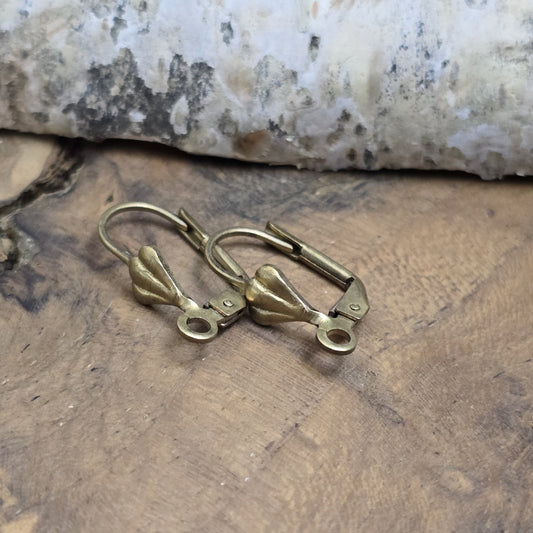 Das Bild zeigt Klappbrisuren mit Blattmotiv - antik bronzefarbig
Die Brisuren haben im vorderen Teil ein barockes Blatt, was ihnen einen gewissen Vintage-Charme verleiht. Geöffnet und geschlossen werden sie mittels eine Klappbügels. Im unteren Teil befindet sich eine Öse die aufgebogen werden kann um dort kleine Anhänger anzubringen. 