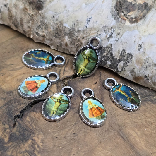 Das Bild zeigt kleinen Anhänger zeigen religiöse Motive. Das Bild ist versiegelt mit Kunstharz um es vor Beschädigungen zu schützen. Auf der Rückseite befindet sich ein Kreuz. Ideal für Armbänder, Ohrschmuck und andere kreative Anwendungen. 