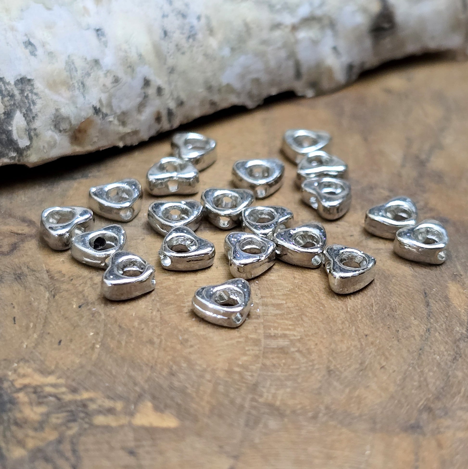 Das Bild zeigt dekorative Herzperlen mit antikem Finish, sie bringen einen charmanten und eleganten Touch in deine Schmuckkreationen. Perfekt als Abstandhalter oder zur Betonung dezent stilvoller Details.