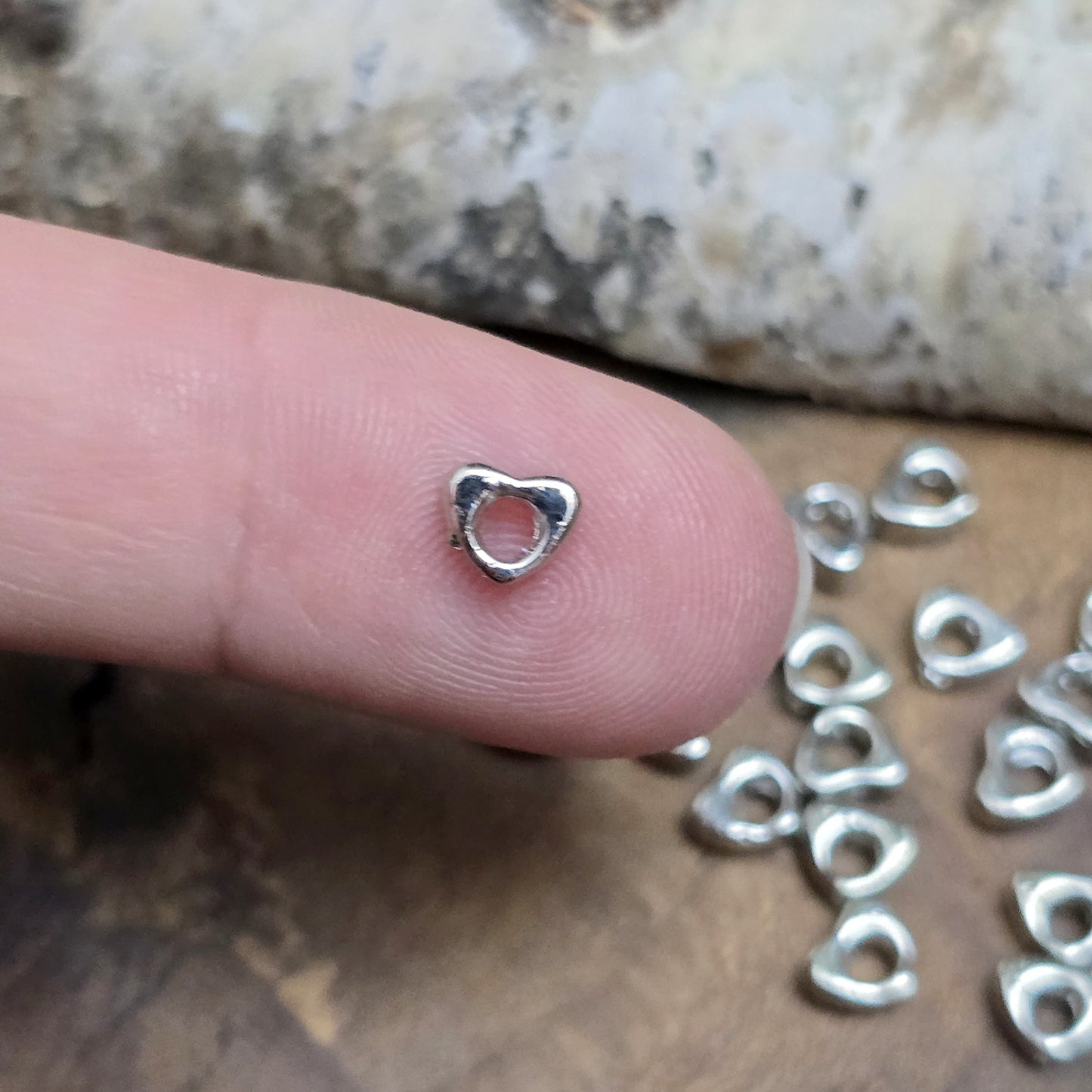 Das Bild zeigt dekorative Herzperlen mit antikem Finish, sie bringen einen charmanten und eleganten Touch in deine Schmuckkreationen. Perfekt als Abstandhalter oder zur Betonung dezent stilvoller Details.