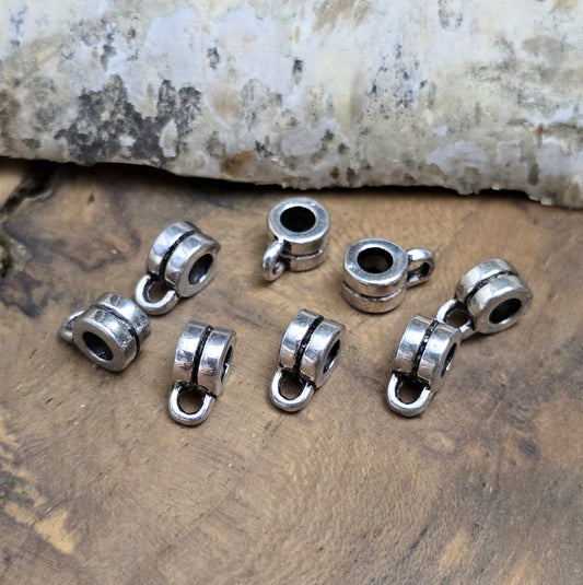 Das Bild zeigt antiksilberfarbene Metallperlen mit Öse. Sie sind eine ideale Ergänzung für kreative Schmuckprojekte. Dank des großzügigen 3-mm-Lochs lassen sie sich mühelos auf verschiedene Bänder und Kordeln auffädeln. Die zusätzliche Öse eröffnet zahlreiche Designmöglichkeiten, um Schmuckstücke individuell zu gestalten.