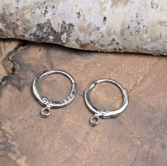 Das Bild zeigt Creolen mit Anhängeröse. Sie sind exquisite Schmuckstücke, die aus 925er Silber gefertigt sind. Mit einem Durchmesser von 13 mm (außen) sind sie elegant und perfekt für den täglichen Gebrauch oder besondere Anlässe.