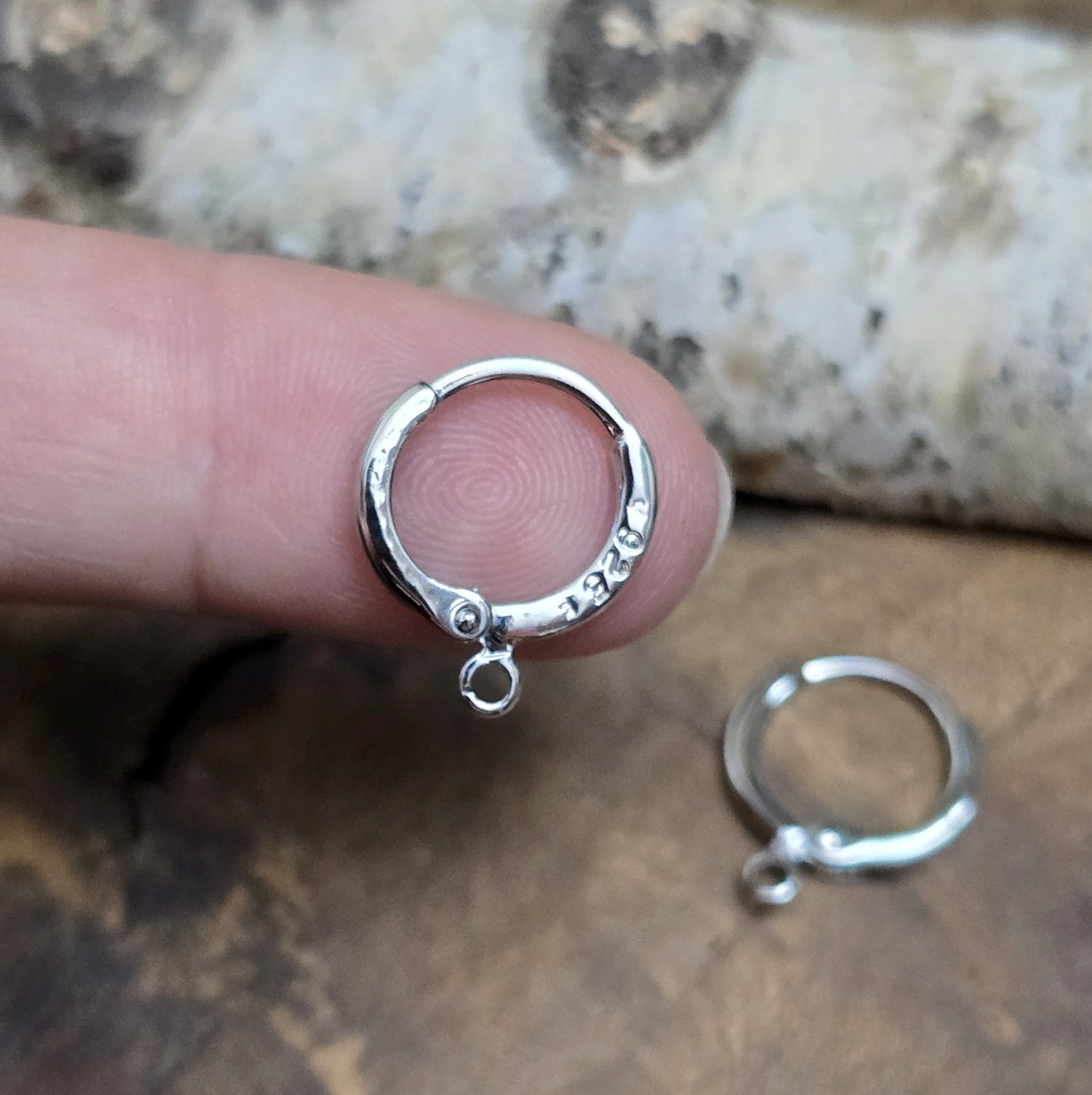Das Bild zeigt Creolen mit Anhängeröse. Sie sind exquisite Schmuckstücke, die aus 925er Silber gefertigt sind. Mit einem Durchmesser von 13 mm (außen) sind sie elegant und perfekt für den täglichen Gebrauch oder besondere Anlässe.