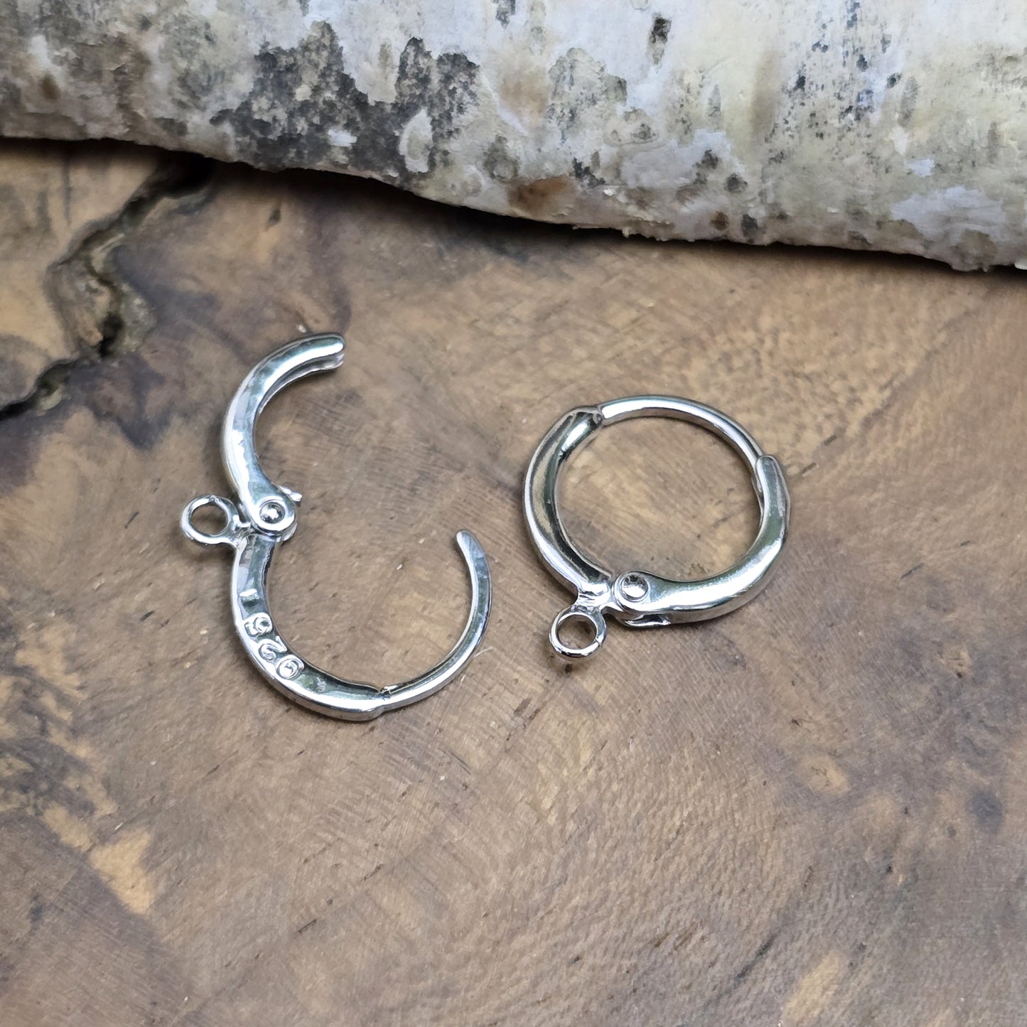 Das Bild zeigt Creolen mit Anhängeröse. Sie sind exquisite Schmuckstücke, die aus 925er Silber gefertigt sind. Mit einem Durchmesser von 13 mm (außen) sind sie elegant und perfekt für den täglichen Gebrauch oder besondere Anlässe.