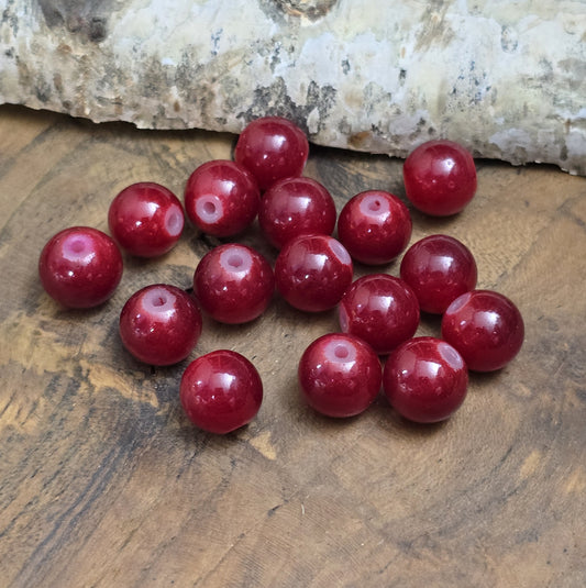 Das Bild zeigt dunkelrote Glasperlen. Die Perlen eignen sich hervorragend für die Herstellung von Armbändern, Halsketten, Ohrringen oder anderen Schmuckstücken. Ob als Hauptbestandteil oder Akzent – sie fügen sich harmonisch in jede Kreation ein.