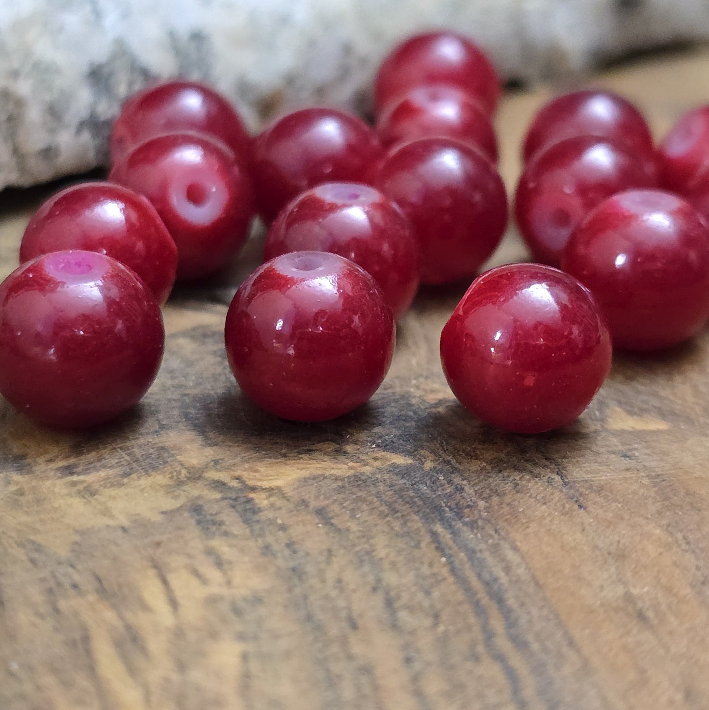 Das Bild zeigt dunkelrote Glasperlen. Die Perlen eignen sich hervorragend für die Herstellung von Armbändern, Halsketten, Ohrringen oder anderen Schmuckstücken. Ob als Hauptbestandteil oder Akzent – sie fügen sich harmonisch in jede Kreation ein.