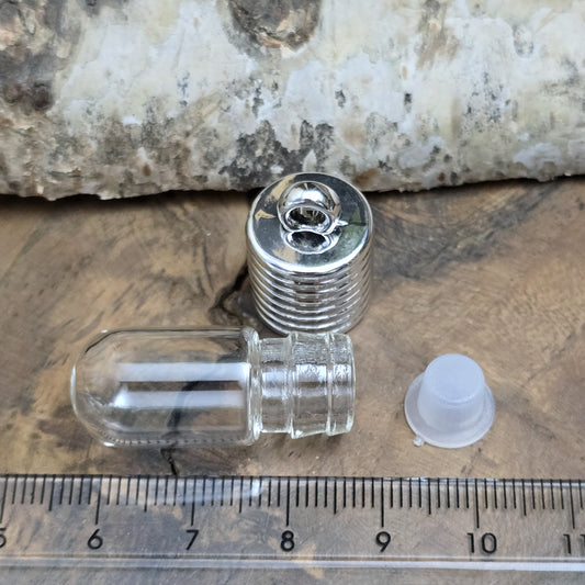 Anhänger Glasflasche mit rundem Boden zum selber befüllen. Die Glasflasche hat oben eine "große" Öffnung und bietet Platz für eine Vielzahl von Erinnerungen und Materialien wie Edelsteinsplitter, Sand, Glitzer, Granulat, Tierhaare, Milchzähne, kleine Turmdeckelschnecken etc. (bitte beachten Sie die Öffnungsgröße).
