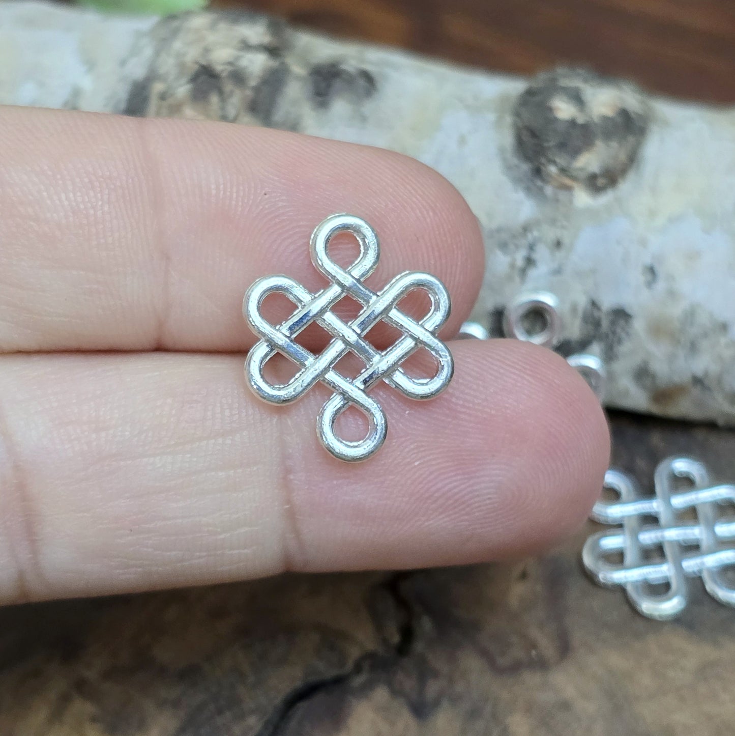 Hell silberfarbige Schmuckverbinder in Form eines chinesischen Glücksknotens. Super für vielerlei Glücksbringerprojekte wie Schlüsselanhänger, Ketten, Armbänder etc.