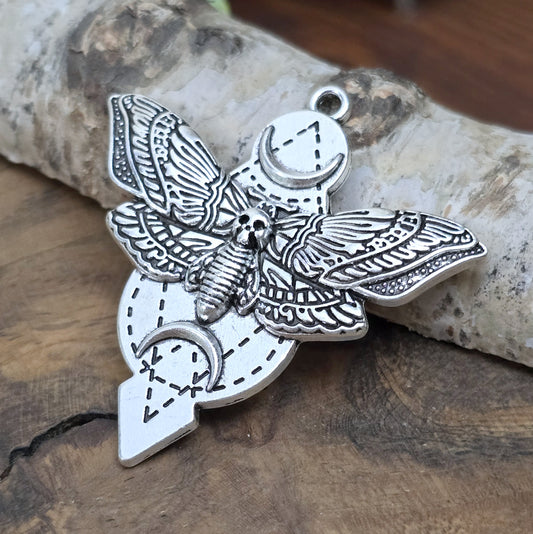Der Anhänger zeigt einen Nachtschwärmer mit Totenkopf (Totenkopfmotte), der von zwei Halbmonden umgeben ist. Dieses einzigartige Design macht ihn zu einer vielseitigen Ergänzung für Ketten, Choker, Schlüssel, Taschen und vieles mehr.