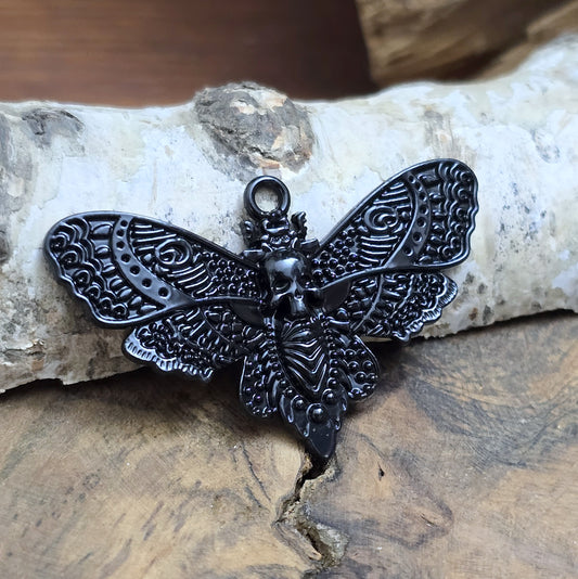 Das Bild zeigt einen Anhänger mit schwarzer Beschichtung. Mit 27 mm Breite und einer stabilen Öse eignet er sich perfekt für Ketten, Choker und andere individuelle Schmuckstücke.