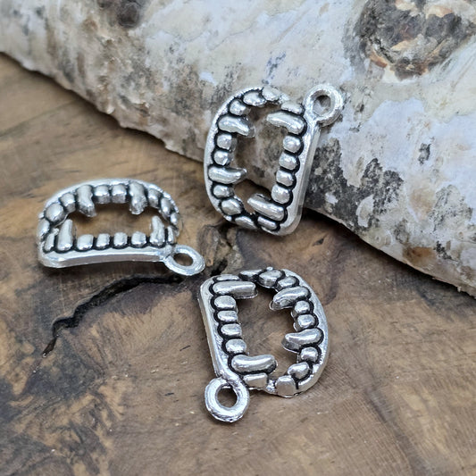 Das Bild zeigt 3 Charms Anhänger Vampirzähne in antik silberfarbig, 18mm. Ideal für die Schmuckherstellung.