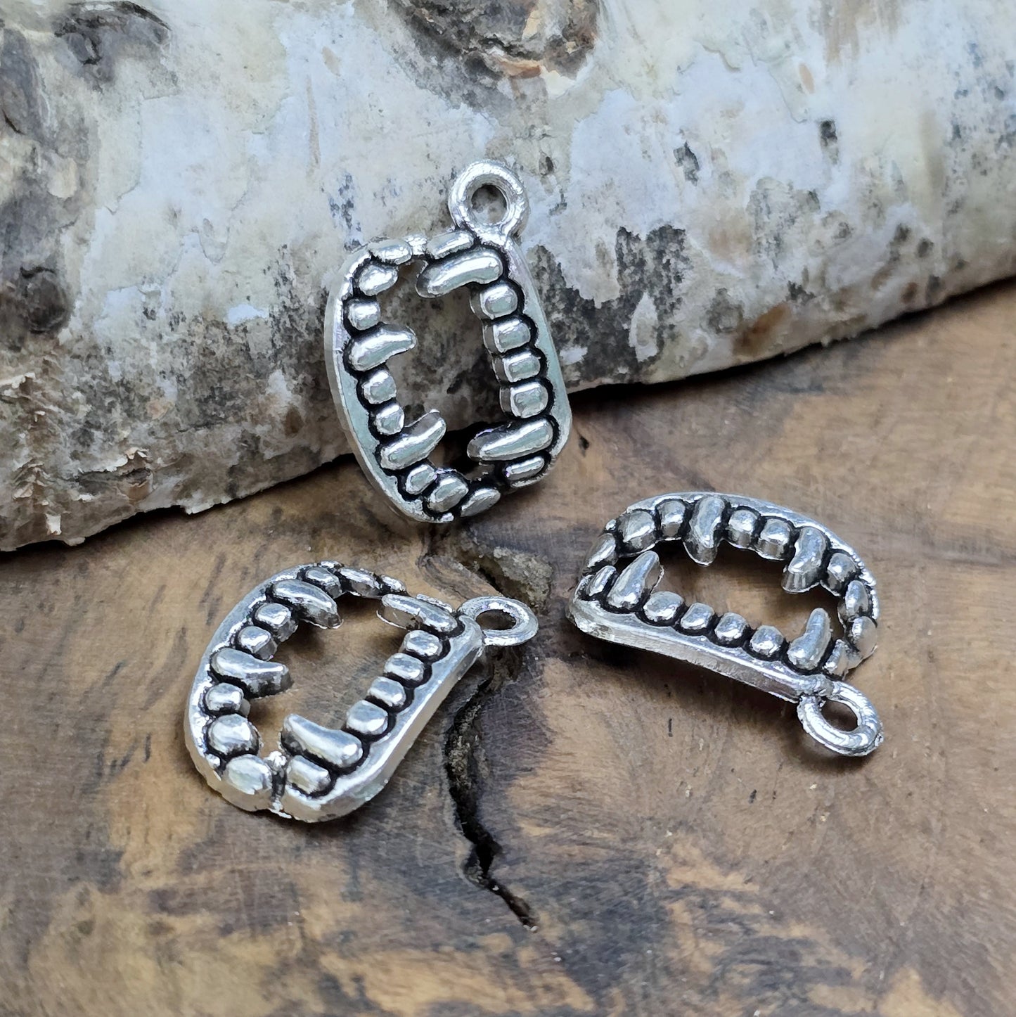 Das Bild zeigt 3 Charms Anhänger Vampirzähne in antik silberfarbig, 18mm. Ideal für die Schmuckherstellung.
