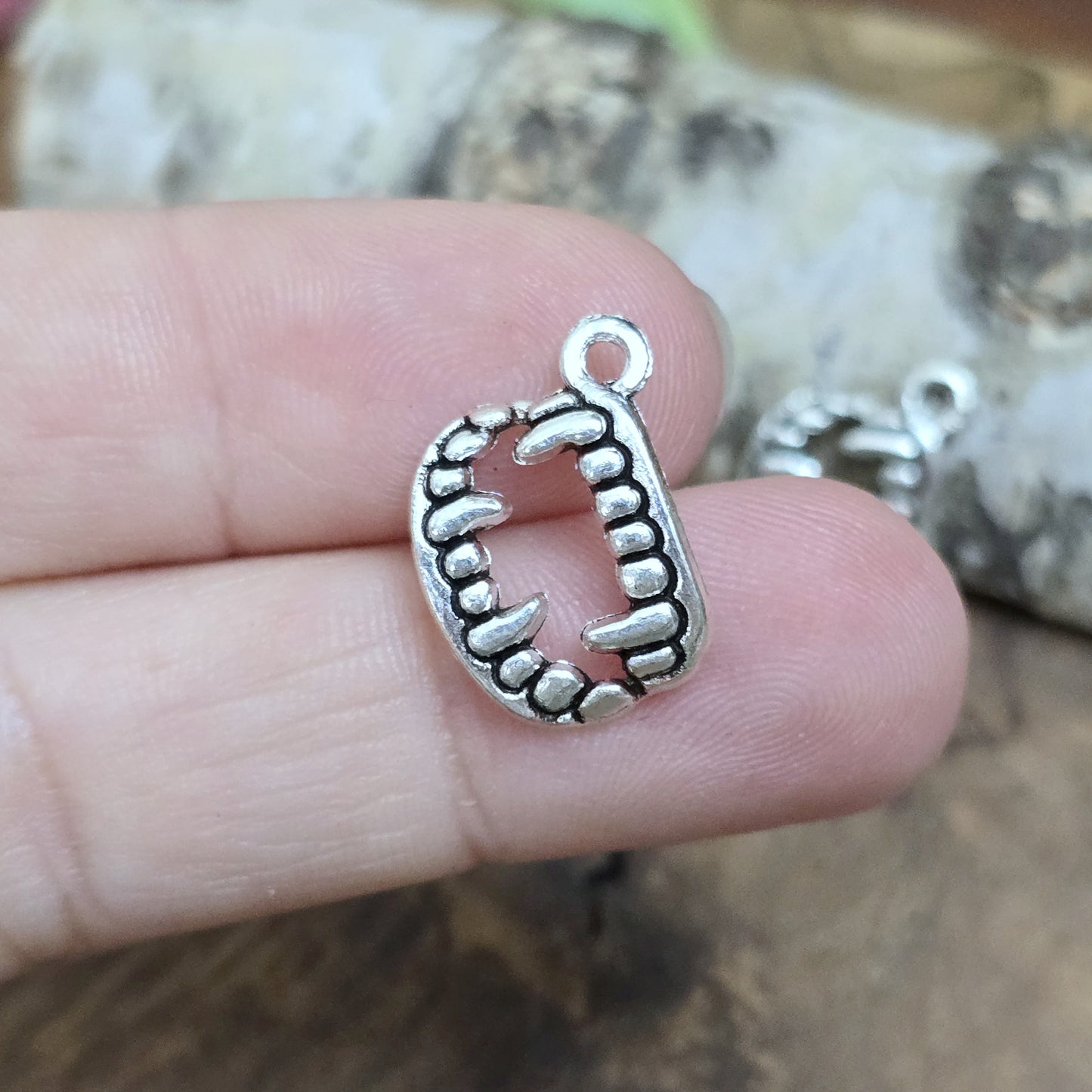 Das Bild zeigt 3 Charms Anhänger Vampirzähne in antik silberfarbig, 18mm. Ideal für die Schmuckherstellung.