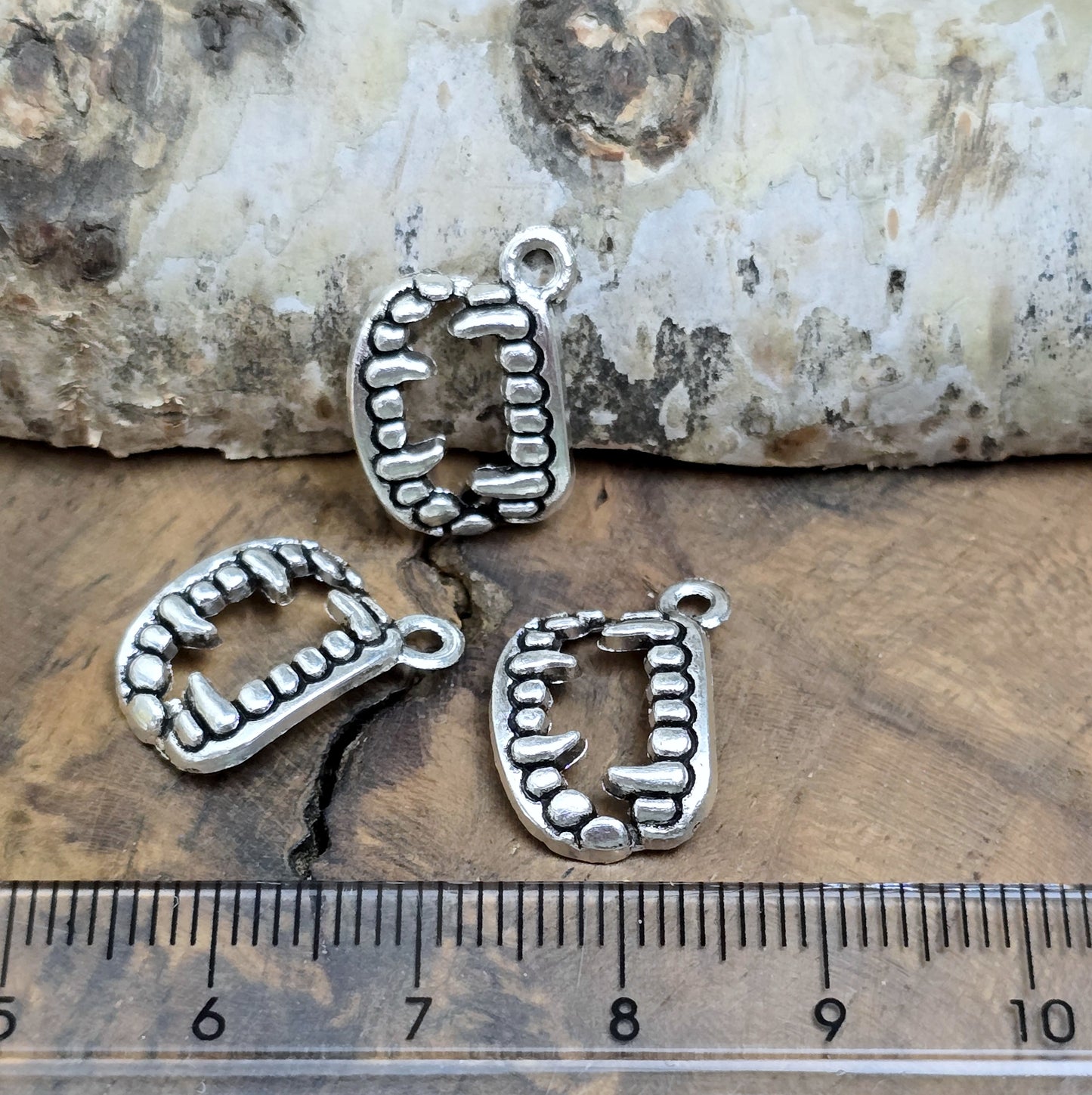 Das Bild zeigt 3 Charms Anhänger Vampirzähne in antik silberfarbig, 18mm. Ideal für die Schmuckherstellung.