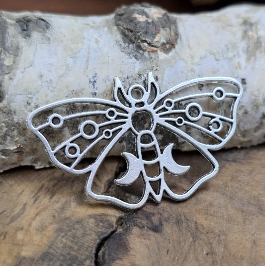 Das Bild zeigt einen bezaubernden Anhänger in Form einer Motte, umgeben von Monden und Planeten, sind perfekt für deine Schmuckkollektion und spirituelle Projekte.
