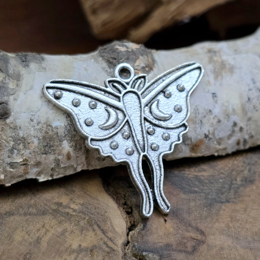 Das Bild zeigt einen Anhänger der auf der Vorderseite ein wunderschönes Relief mit zwei Monden hat, während die Rückseite glatt ist. Oben befindet sich eine feste Öse, die ihn perfekt für die Schmuckherstellung macht. Du kannst ihn sogar individuell gestalten, indem du die Flügel und den Körper farblich anpasst – so bekommt er deine ganz persönliche Note.