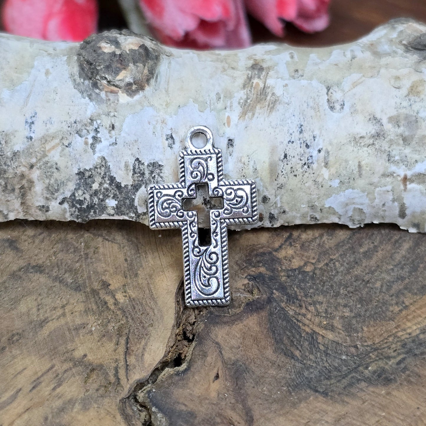 Das Bild zeigt einen charmanten Kreuz-Anhänger in antik silberfarbiger Ausführung. Mit einer Größe von 23 mm sind sie ideal für Ihre individuelle Schmuckherstellung.