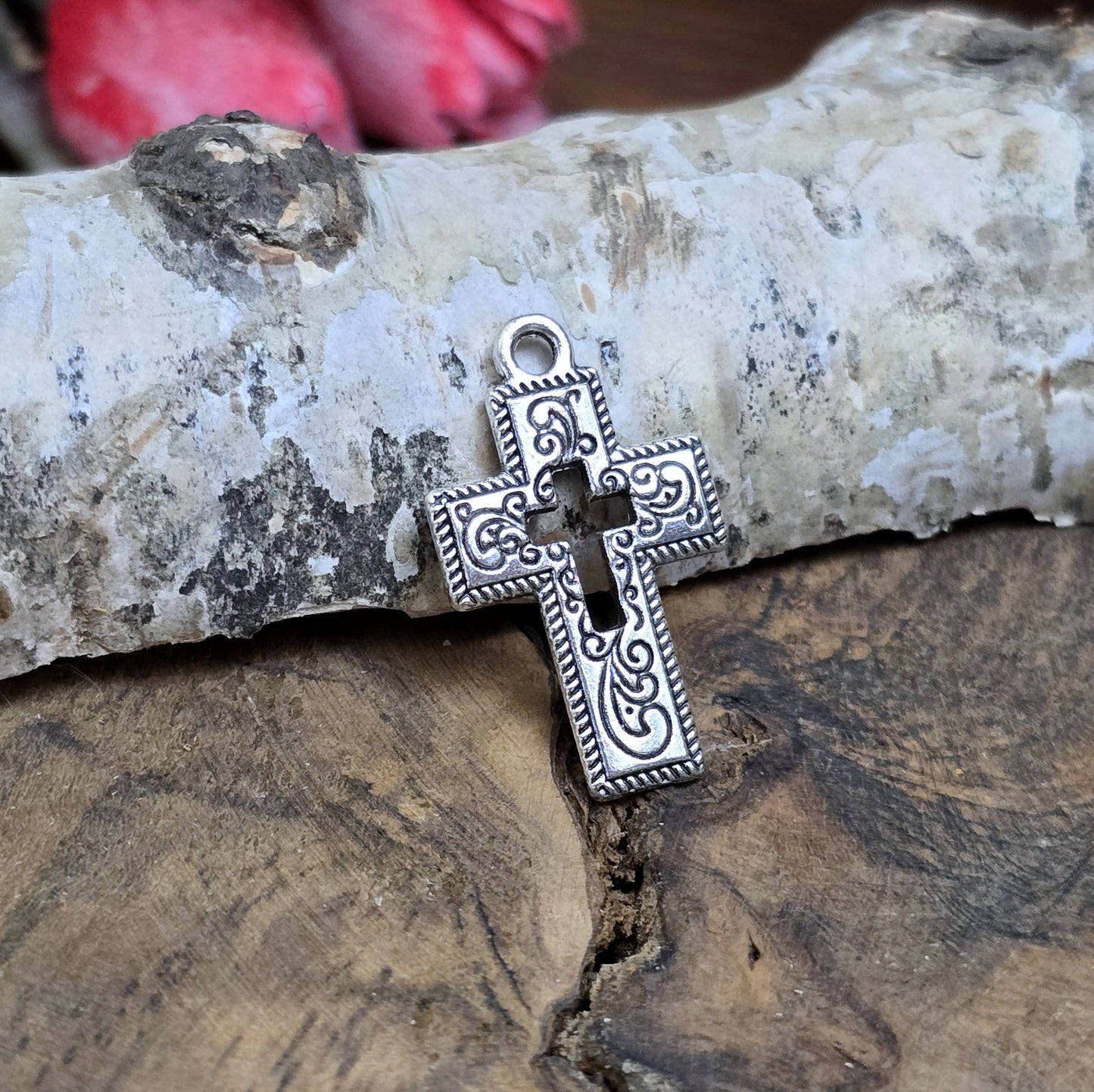 Das Bild zeigt einen charmanten Kreuz-Anhänger in antik silberfarbiger Ausführung. Mit einer Größe von 23 mm sind sie ideal für Ihre individuelle Schmuckherstellung.