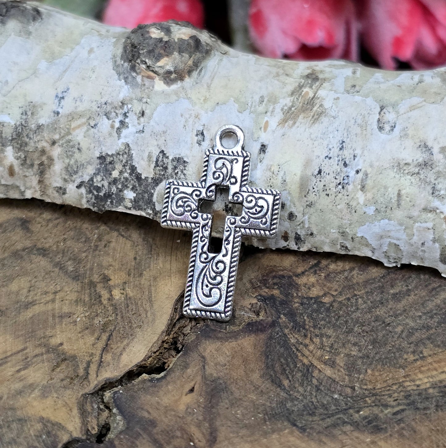 Das Bild zeigt einen charmanten Kreuz-Anhänger in antik silberfarbiger Ausführung. Mit einer Größe von 23 mm sind sie ideal für Ihre individuelle Schmuckherstellung.