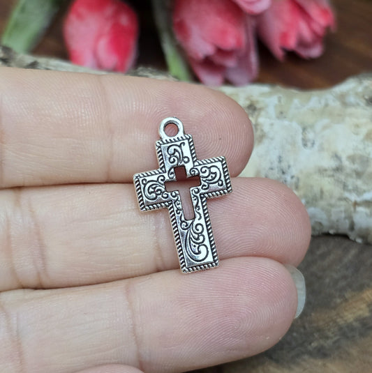 Das Bild zeigt einen charmanten Kreuz-Anhänger in antik silberfarbiger Ausführung. Mit einer Größe von 23 mm sind sie ideal für Ihre individuelle Schmuckherstellung.