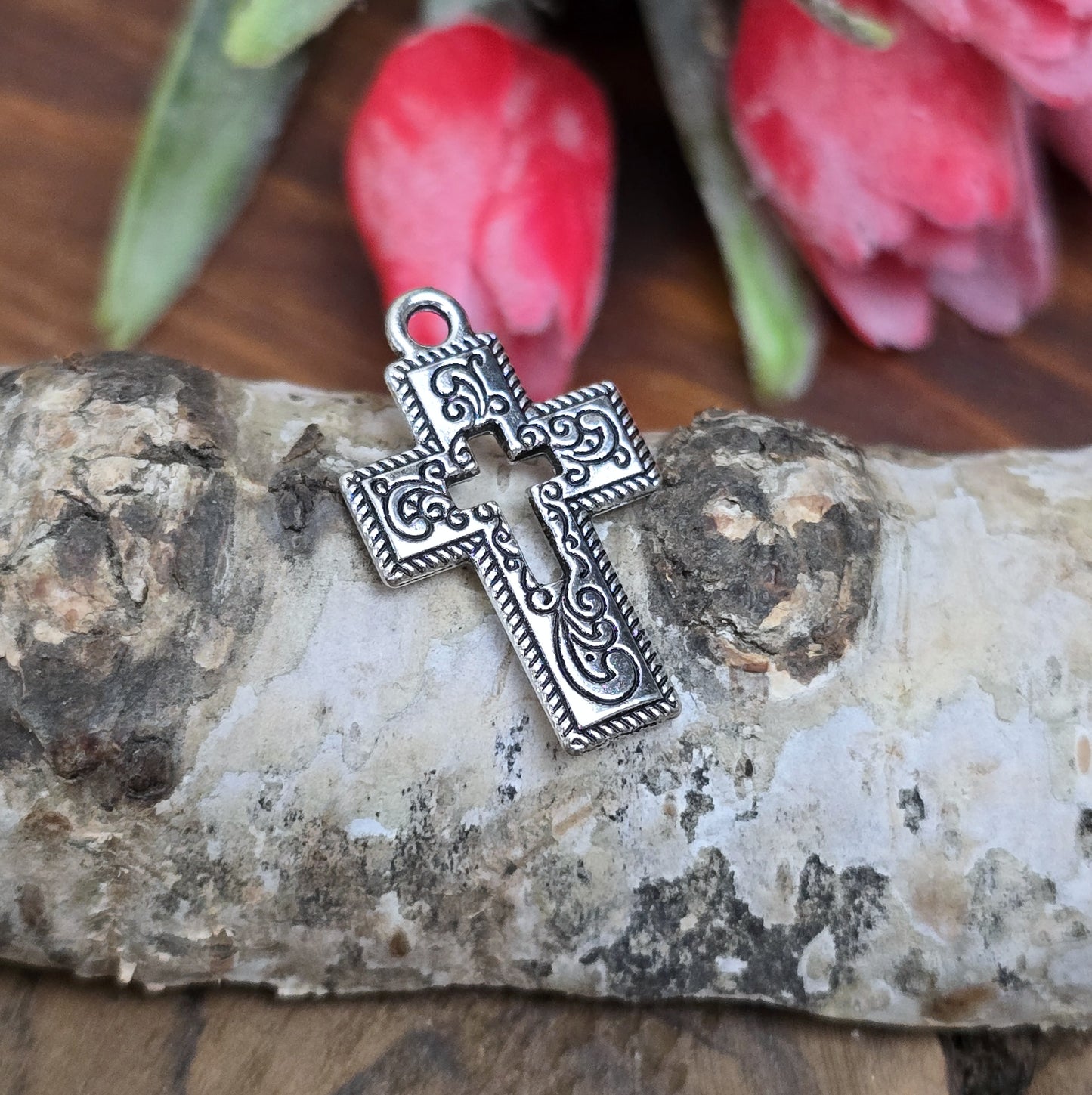 Das Bild zeigt einen charmanten Kreuz-Anhänger in antik silberfarbiger Ausführung. Mit einer Größe von 23 mm sind sie ideal für Ihre individuelle Schmuckherstellung.