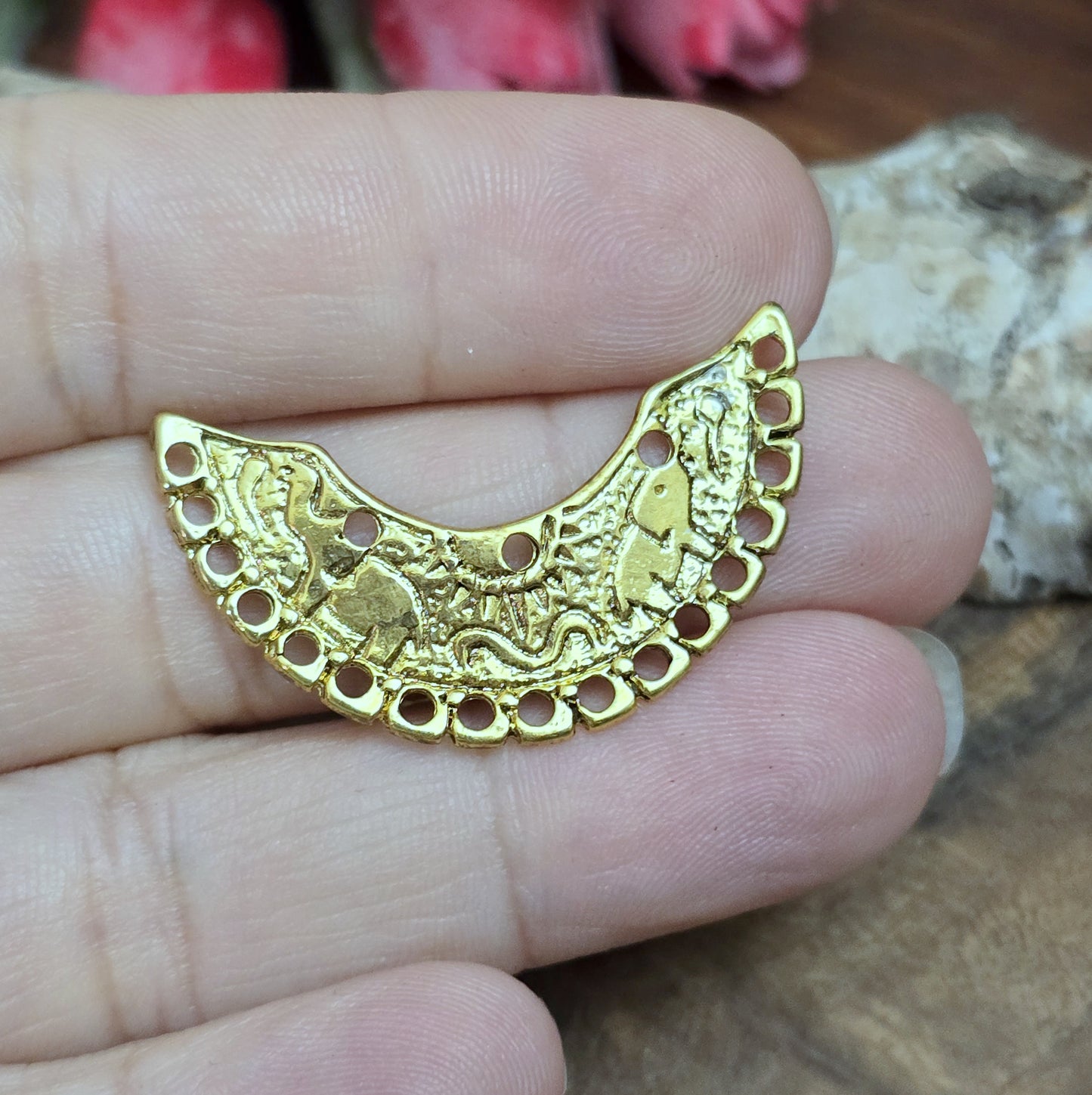 2 einzigartige, halbrunde Multiverbinder im Bollywood-Stil. Die ideale Schmuckkomponente für Tiaras, Fußschmuck, Handketten und Ohrschmuck im beliebt indischen Bollywood-Design. Die Verbinder sind antik silberfarbig und verfügen im inneren Bogen über 3 Löcher und am unteren Außenbogen befinden sich 17 Löcher. Auf dem Bogen selbst sind 2 Elefanten abgebildet sowie eine Sonne.