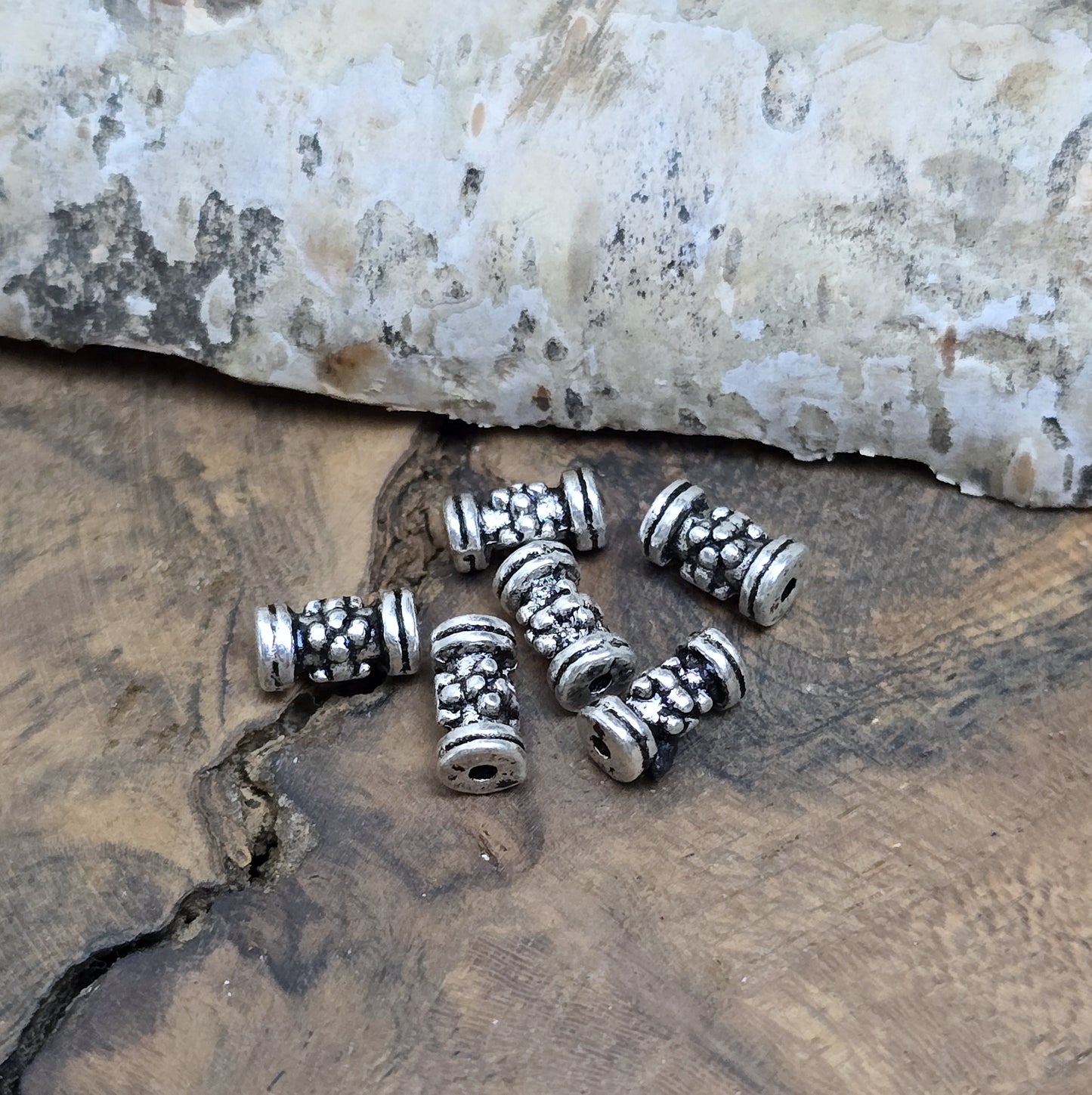 12 Ethno Metallperlen Tube, Walze, 7x3mm, antik silberfarbig
Setze eindrucksvolle Akzente in deinen Schmuckkreationen mit diesen 12 kleinen, walzenförmigen Metallperlen, die mit einem ansprechenden Ethno-Muster versehen sind.