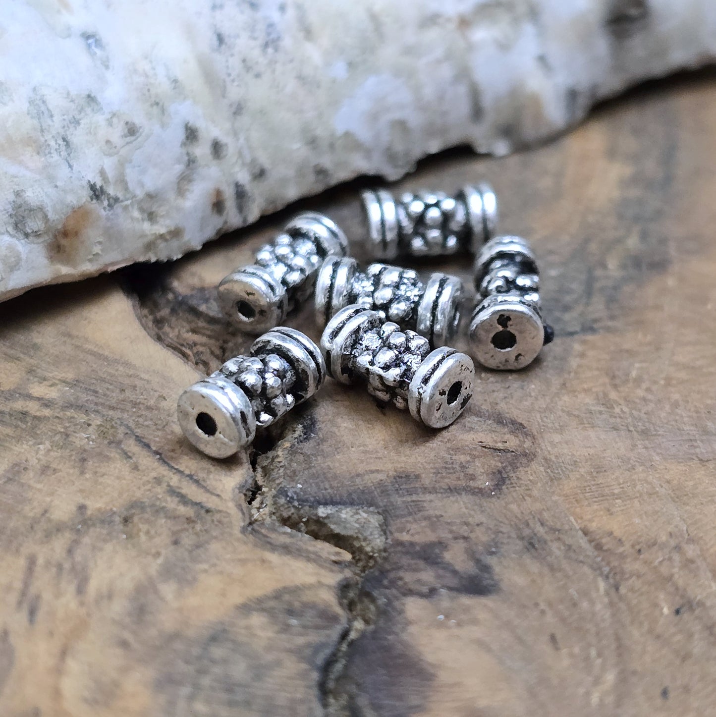 12 Ethno Metallperlen Tube, Walze, 7x3mm, antik silberfarbig
Setze eindrucksvolle Akzente in deinen Schmuckkreationen mit diesen 12 kleinen, walzenförmigen Metallperlen, die mit einem ansprechenden Ethno-Muster versehen sind.