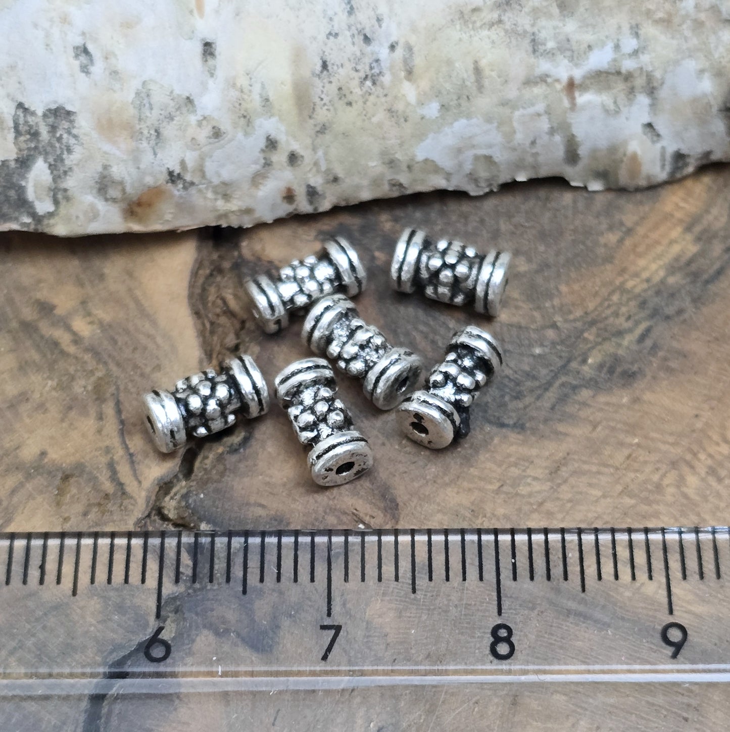 12 Ethno Metallperlen Tube, Walze, 7x3mm, antik silberfarbig
Setze eindrucksvolle Akzente in deinen Schmuckkreationen mit diesen 12 kleinen, walzenförmigen Metallperlen, die mit einem ansprechenden Ethno-Muster versehen sind.