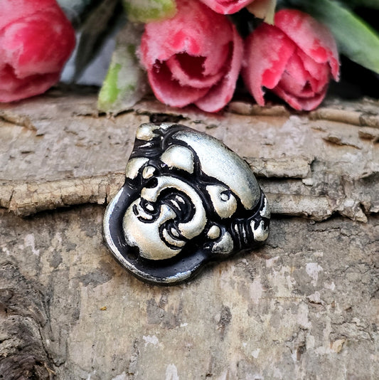 Das Bild zeigt einen handgefertigten Anhänger in Form eines lachenden Buddhas, gefertigt aus schwarzem Kunstharz mit roségoldenen Details. Der Buddha hat eine flache Rückseite und ein kleines Loch im oberen Bereich für eine Anhängeröse. Der Anhänger eignet sich hervorragend für Schmuckkreationen, Bastelprojekte oder zum Verzieren von Dekorationen.