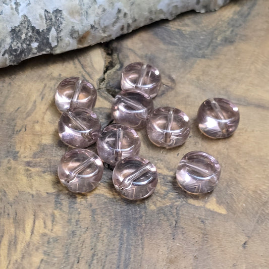 Das Bild zeigt kleine münzförmige Glasperlen in der Farbe Amethyst, für die individuelle Schmuckherstellung.