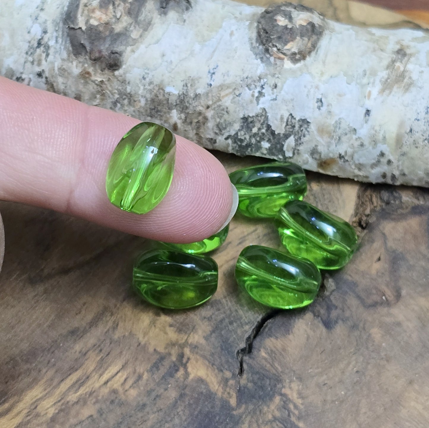 Das Bild zeigt 2 transparente Glasperlen in Nuggetform – Grün – 13mm – Frische Eleganz für deine Schmuckkreationen