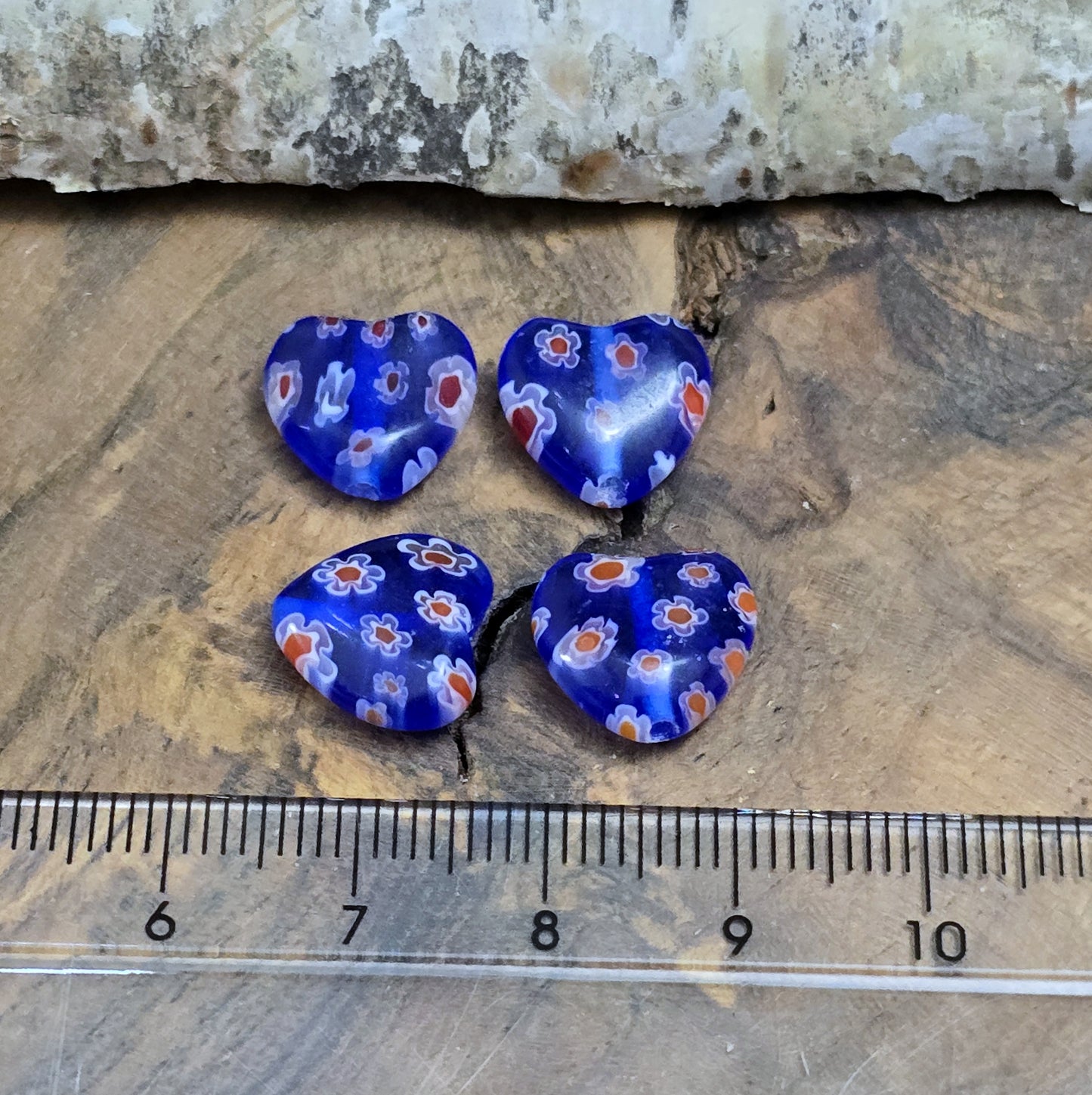 Das Bild zeigt 4 Millefiori Glasperlen – Herzform – Blau – 12mm – Romantische Akzente für deine Schmuckkreationen