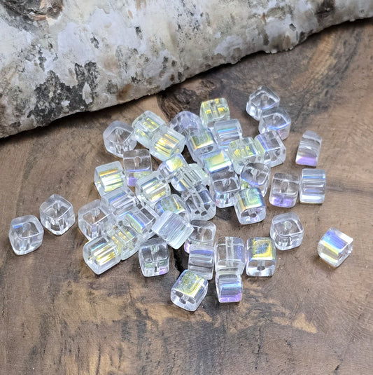Das Bild zeigt 40 kleine Glasperlen – Würfelform – Crystal AB – 4mm – Funkelnde Eleganz für deine Schmuckkreationen
