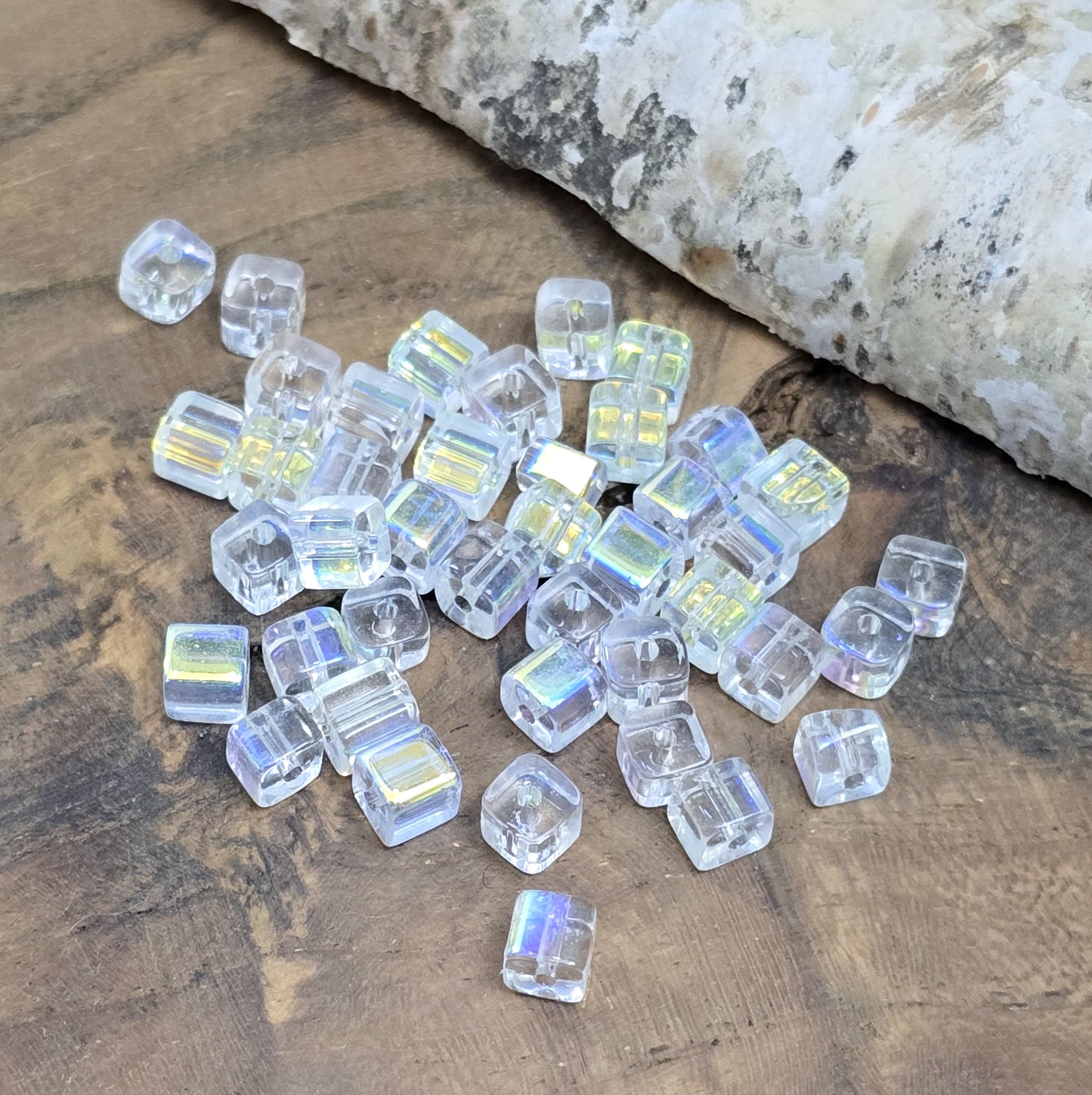 Das Bild zeigt 40 kleine Glasperlen – Würfelform – Crystal AB – 4mm – Funkelnde Eleganz für deine Schmuckkreationen