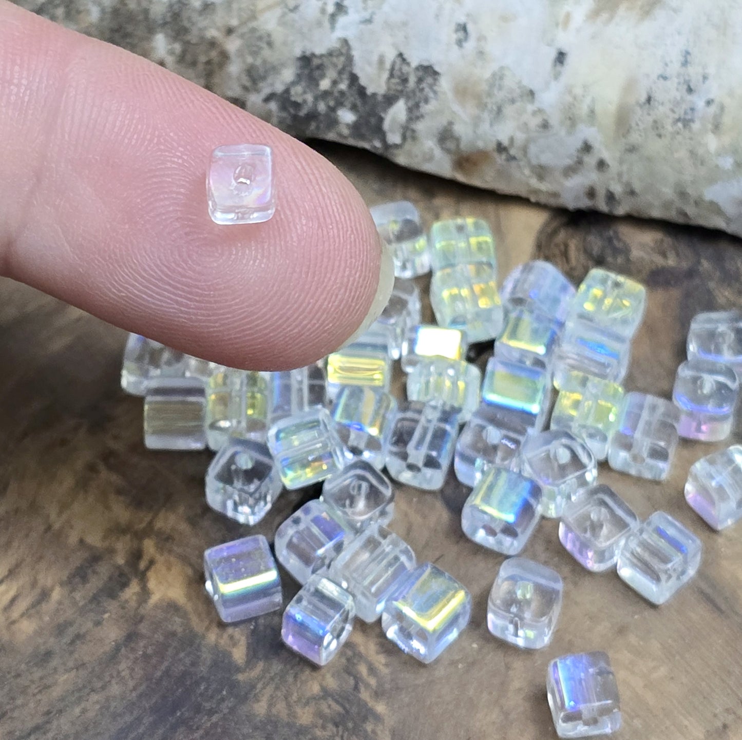 Das Bild zeigt 40 kleine Glasperlen – Würfelform – Crystal AB – 4mm – Funkelnde Eleganz für deine Schmuckkreationen