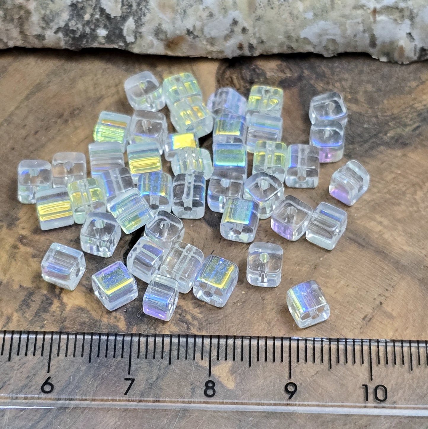 Das Bild zeigt 40 kleine Glasperlen – Würfelform – Crystal AB – 4mm – Funkelnde Eleganz für deine Schmuckkreationen