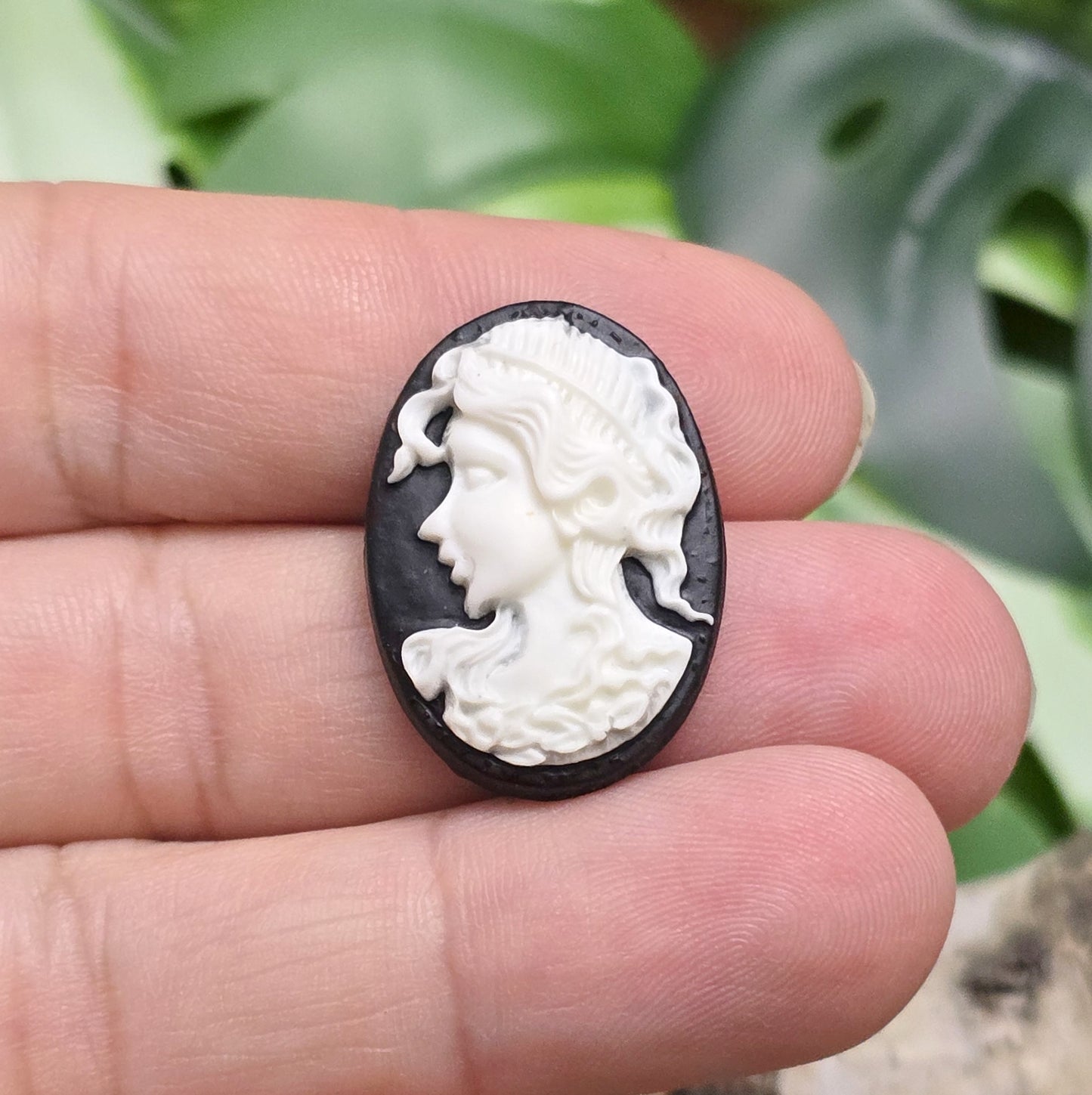 Das Bild zeigt einen ovalen Kamee-Cabochon – 25 x 18mm – Schwarz mit weißem Relief – Vintage-Charme für deine DIY-Kreationen