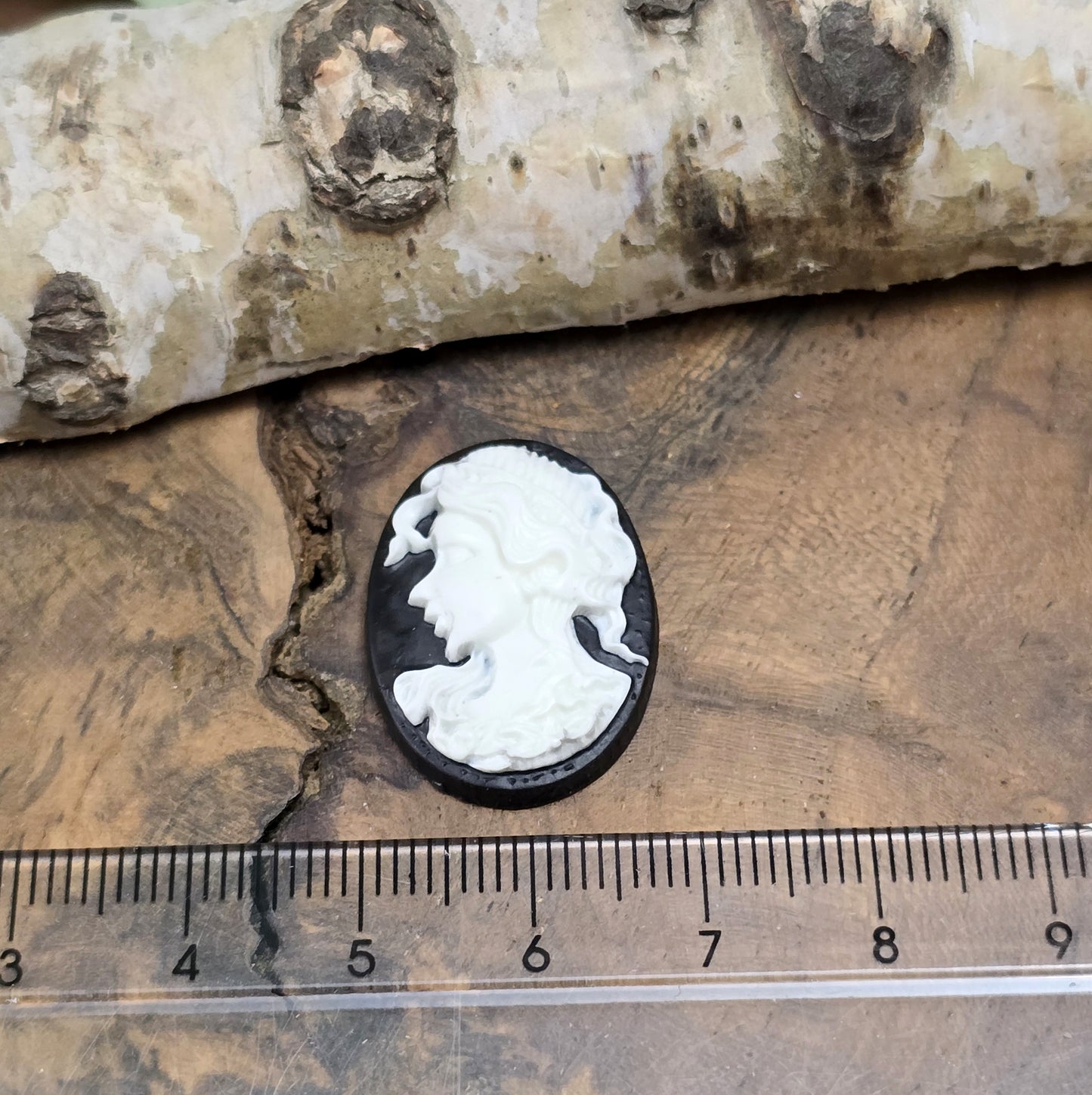 Das Bild zeigt einen ovalen Kamee-Cabochon – 25 x 18mm – Schwarz mit weißem Relief – Vintage-Charme für deine DIY-Kreationen
