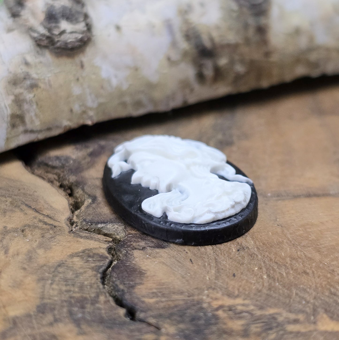 Das Bild zeigt einen ovalen Kamee-Cabochon – 25 x 18mm – Schwarz mit weißem Relief – Vintage-Charme für deine DIY-Kreationen