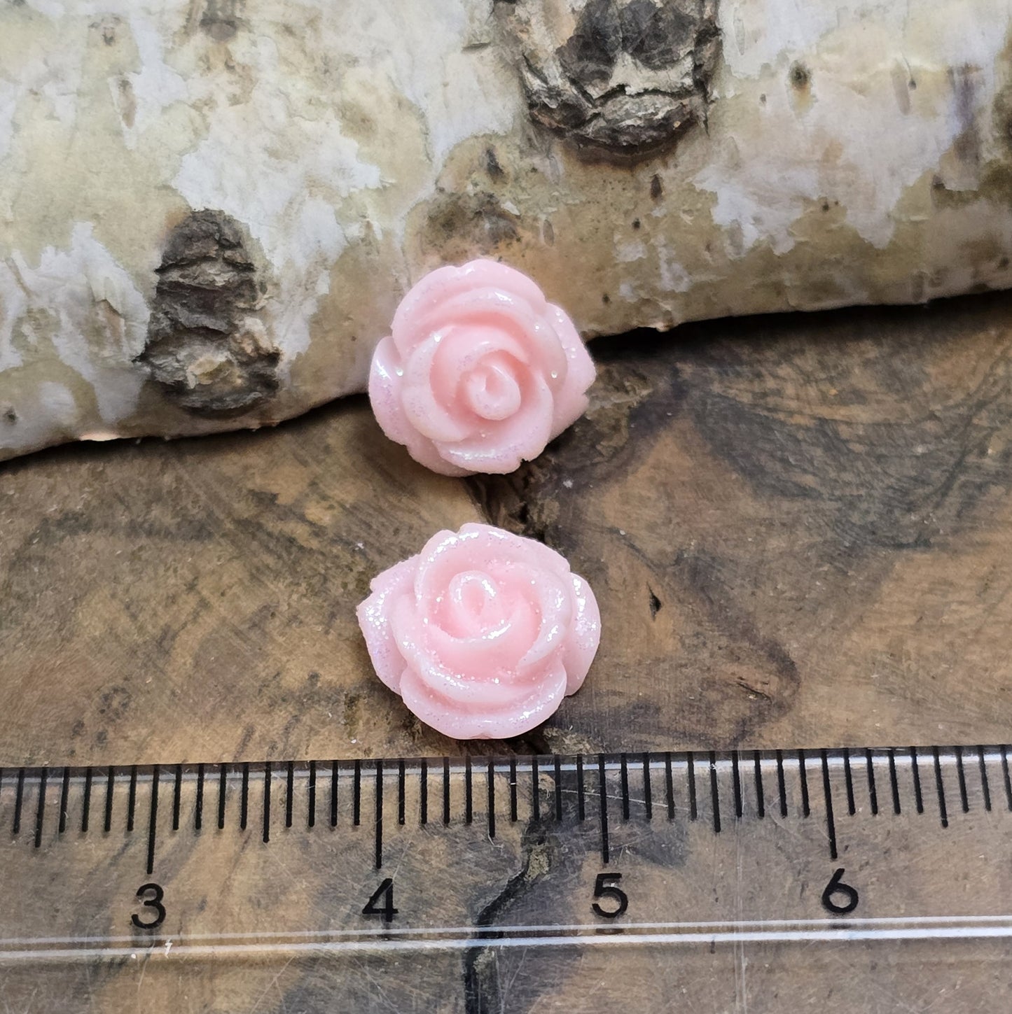 Das Bild zeigt glitzernde Röschen aus Resin – 11mm – Rosa – Perfekt für Schmuck & kreative DIY-Projekte ✨🌹