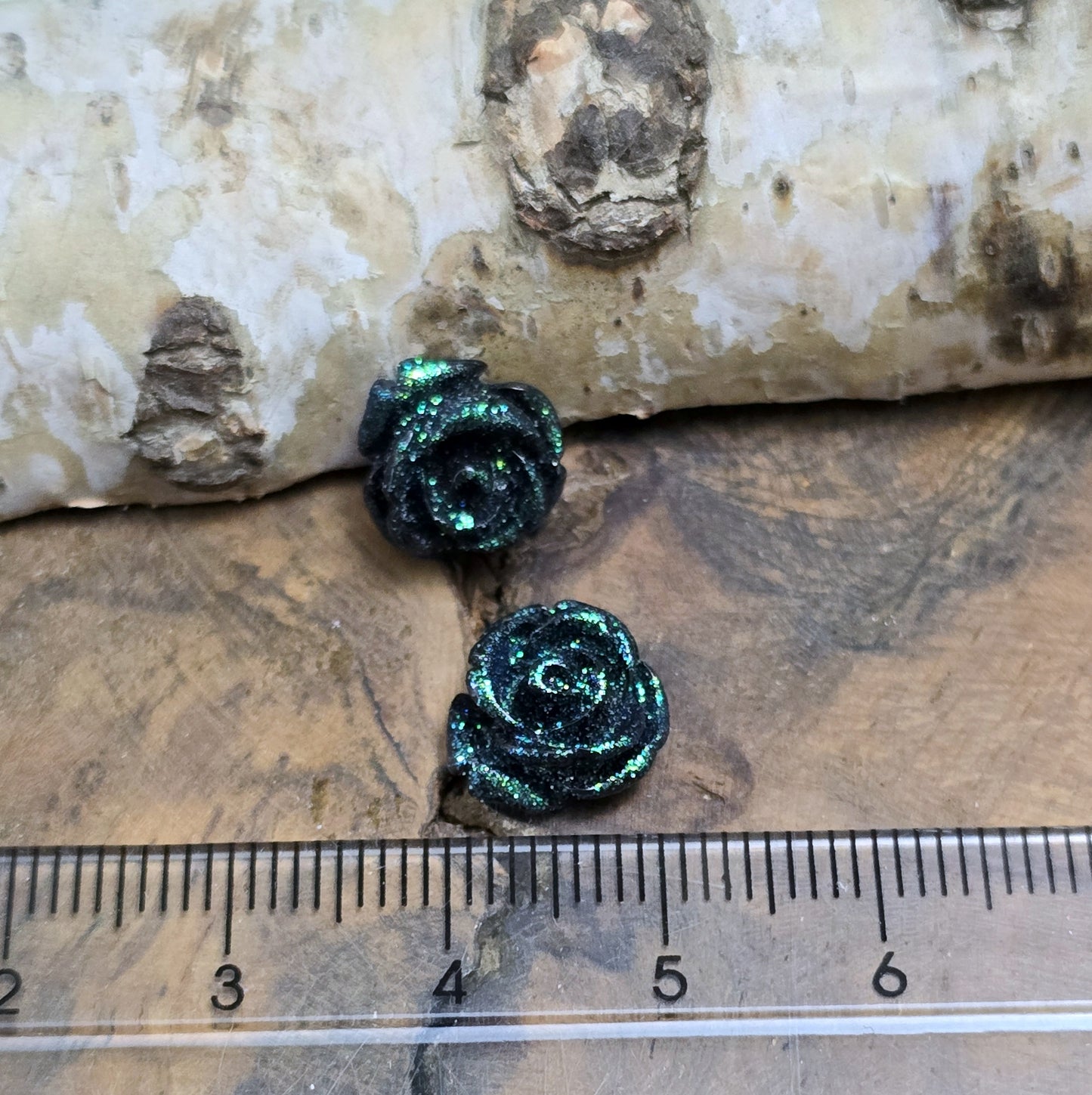 Das Bild zeigt glitzernde Röschen aus Resin – 11mm – Schwarz – Edler Glanz für deine Schmuckkreationen ✨🌹