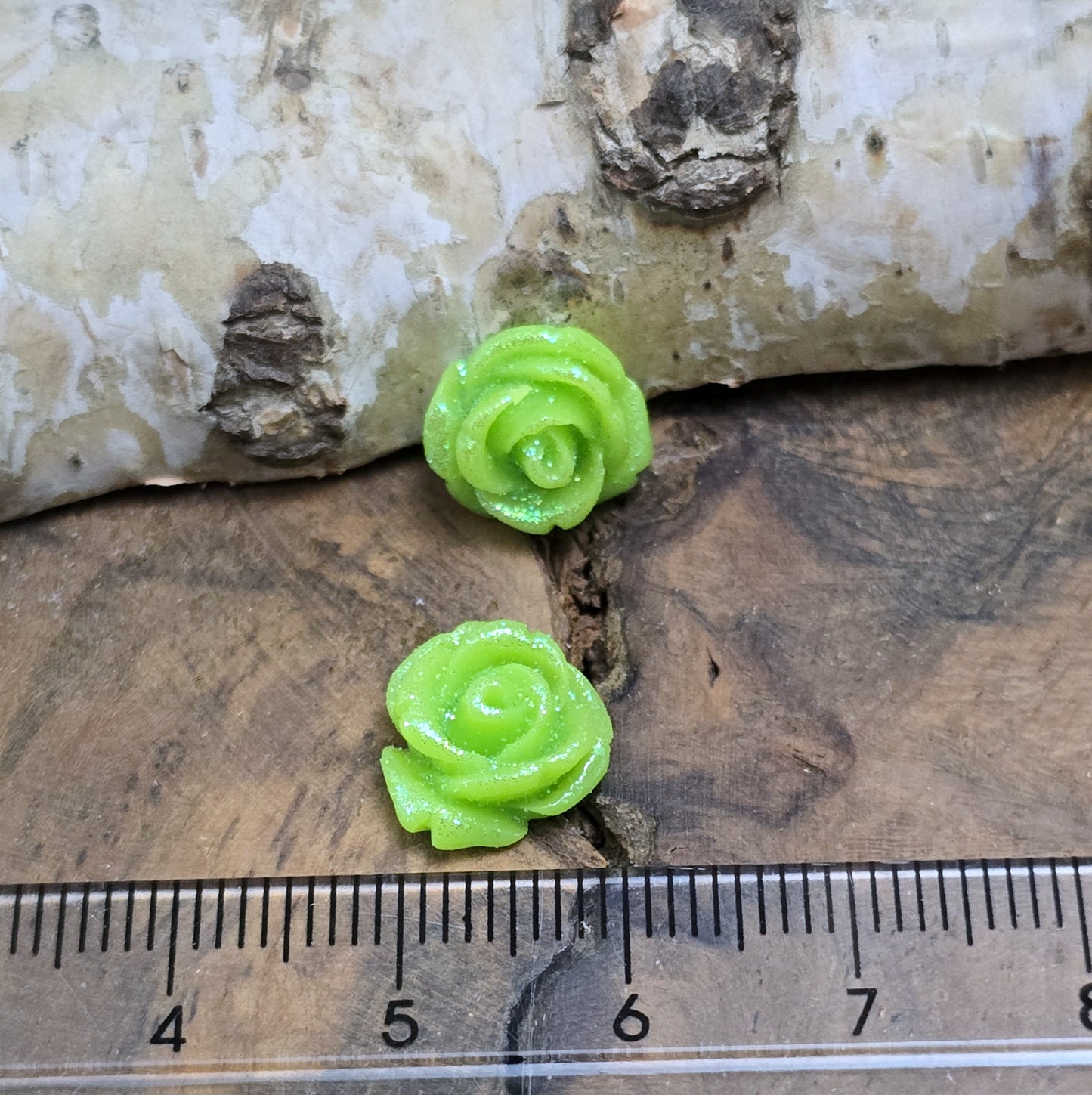 Das Bild zeigt glitzernde Röschen aus Resin – 11mm – Grün – Frische Eleganz für deine Schmuckkreationen ✨🌿