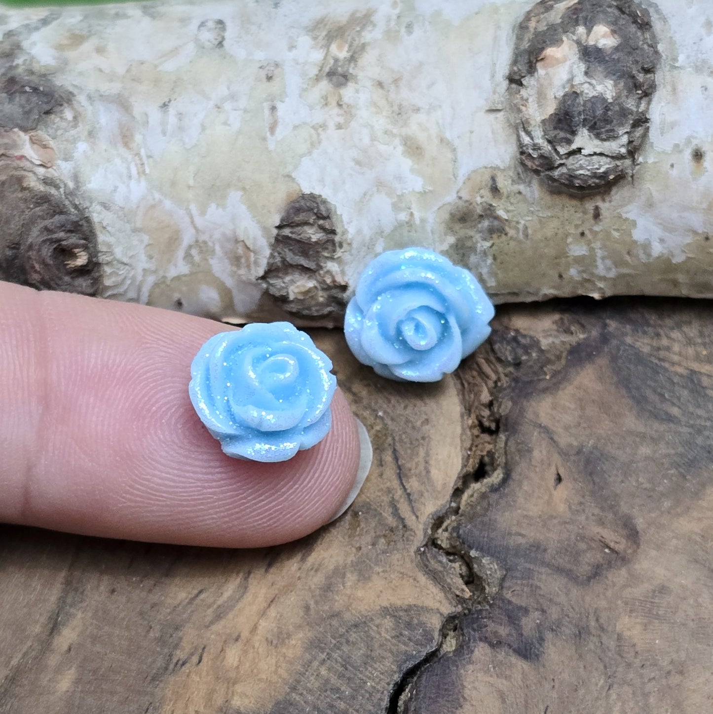 Das Bild zeigt glitzernde Röschen aus Resin – 11mm – Blau – Elegante Blütenpracht für deine Schmuckkreationen ✨🌊