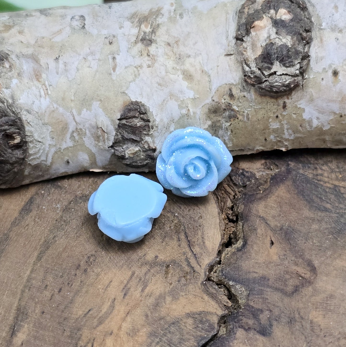 Das Bild zeigt glitzernde Röschen aus Resin – 11mm – Blau – Elegante Blütenpracht für deine Schmuckkreationen ✨🌊